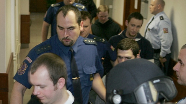 Justiční stráž v obležení speciální jednotky přivádí žháře k soudu. Justiční stráž v obležení speciální jednotky přivádí žháře k soudu.