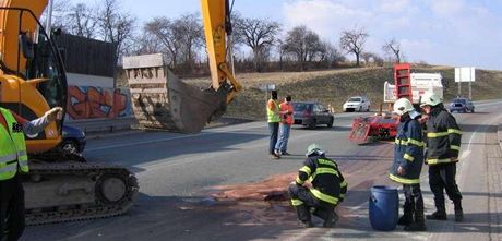 Hasii likvidují skvrny po bagru, který sjel z podvalníku za tahaem. (23. bezna 2010)