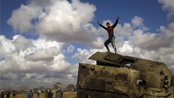 Libyjtí rebelové slaví mezi troskami Kaddáfího transportér (20. bezna 2011)