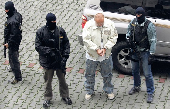 Policisté vedou spoutaného Jaroslava Starku do vazby. (17. listopadu 2006)