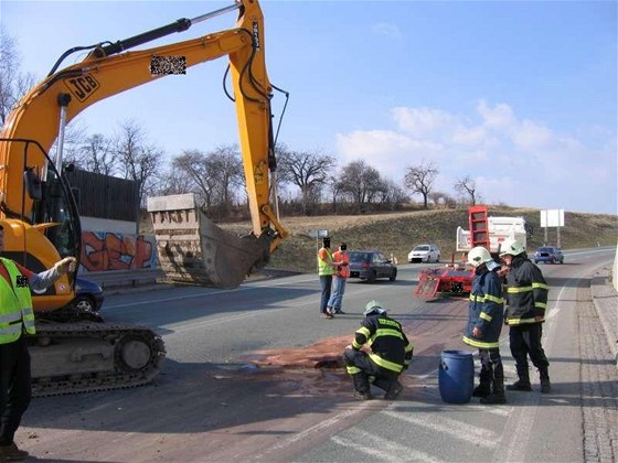 Hasii likvidují skvrny po bagru, který sjel z podvalníku za tahaem. (23. bezna 2010)