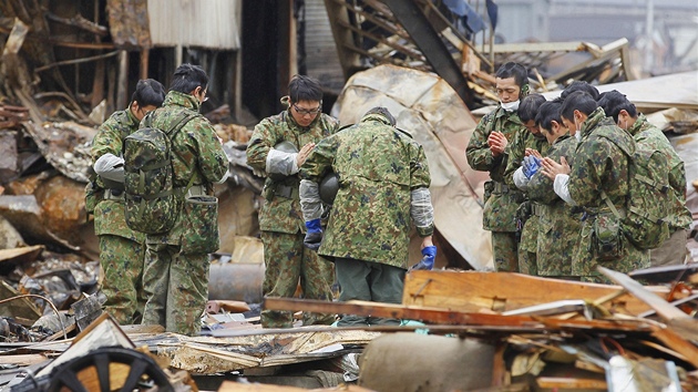 Japontí vojáci se modlí za obti na troskách vyhoelé továrny