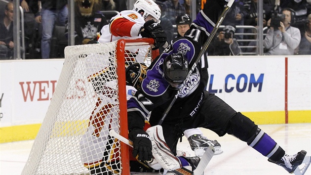 OBSAZENO! Do tak malého prostoru jako je hokejová branka by se víc lidí moná velo, ale jedin bez výstroje. Popít zákon o zachování hmoty se pokouí Wayne Simmonds z Los Angeles, jen padá na calgarského brankáe Miikku Kiprusoffa.