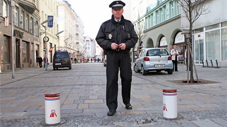 Stráník Petr Carbol dálkovým ovládáním vysouvá sloupky na pí zón v centru Ostravy, aby sem v dob od deseti do osmnácti hodin nemohla jezdit auta.