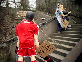 Zamstnanci Sazky odstrauj figurny sportovc viscch ze elezninho mostu v praskch Vysoanech. (4. dubna 2011)