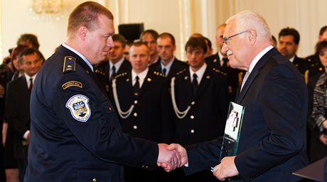 Prezident Václav Klaus oceuje Zlatým záchranáským kíem hasie z Nýan na Plzesku Roberta Kueru a devt jeho koleg, kteí zachránili chlapce uvízlého v hlubokém bahn oputného lomu