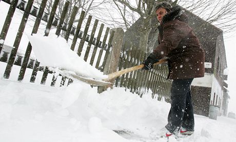 Monika Rusnáková z Boího Daru uklízí sníh ped svým domem - do Kruných hor se 13. dubna vrátil sníh.