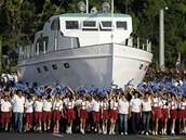Kubnsk dti pochoduj vedle repliky lodi Granma bhem oslav 50. vro vtzstv Castrovch jednotek v Ztoce svin. Lo Granma zapevela bhem dvj revoluce z Mexika na Kubu Castrovy spolubojovnky (16. dubna 2011)