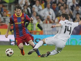 VEDLE! Barcelonsk Lionel Messi (vlevo) obchz s mem Xabiho Alonsa z Realu Madrid.