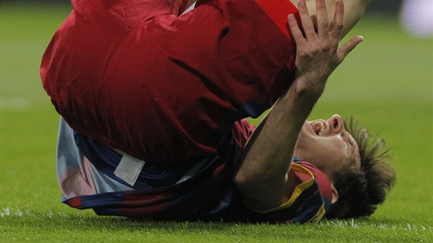 FAUL! Barcelonský útoník Lionel Messi padá v duelu s Realem Madrid.
