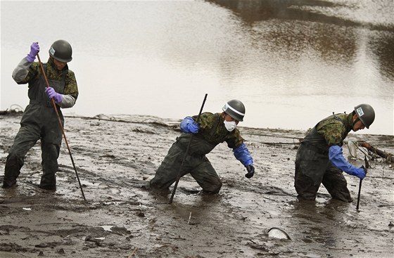 Japontí vojáci hledají v bahn a naplaveninách tla obtí beznového tsunami. (25. dubna 2011)