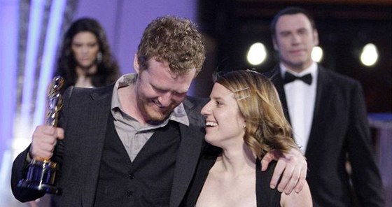 Glen Hansard a Markéta Irglové se radují z Oscara, které ho jim za píse Falling Slowly z filmu Once pedal John Travolta (v pozadí).