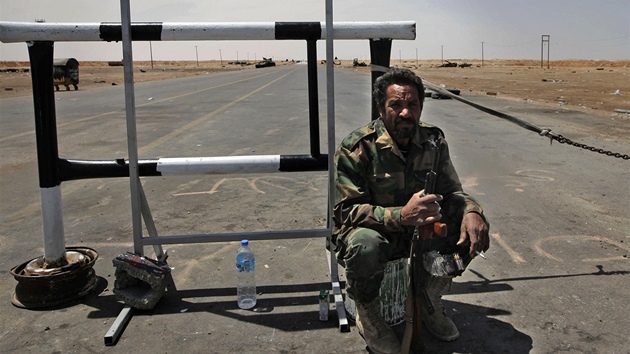 Libyjský rebel u cedule s nápisem "Válená zóna - zákaz vstupu civilistm a novinám" (23. dubna 2011)