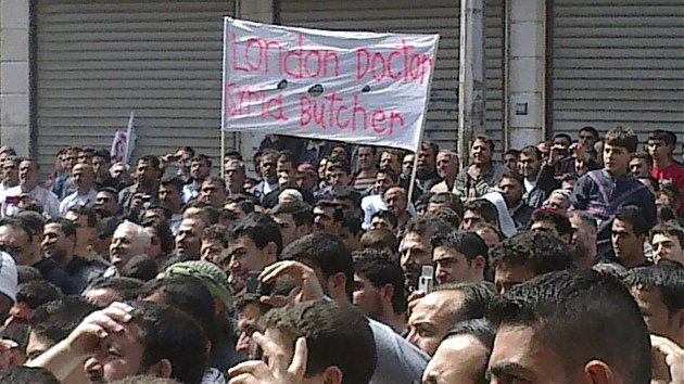 Protesty v Sýrii. Na snímku, který poídil na mobilní telefon jeden z místních, je plakát se slovy: Londýnský doktor, syrský ezník s odkazem na prezidenta Asada, který vystudoval v britské metropoli oní lékaství