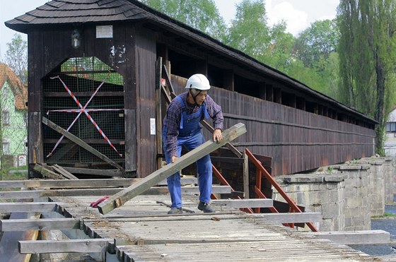 Tesa Vladimír Kuera rozebírá starou a zchátralou konstrukci pedmostí kryté lávky v eském Krumlov. Po loské oprav stechy je to druhá etapa opravy mostu.