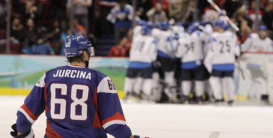 Zatímco hokejisté Finska (v pozadí) slaví zisk bronzových medailí, Slováci se ocitli na kolenou. V tomto pípad konkrétn Milan Jurina.