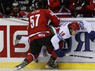 TVRDÝ SOUBOJ U MANTINELU. výcarský hokejista Goran Bezina bojuje o puk s Alexejem Ugarovem z Bloruska.