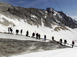 Pracovnci pikrvaj ledovec na nejvy hoe Nmecka Zugspitze. Speciln folie maj zabrnit tn ledovce bhem letn sezony.