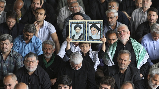Íránský chlapec ukazuje portréty vdc islámské revoluce ajatolláha Chamneího (vlevo) a ajatolláha Chomejního (6. kvtna 2011)