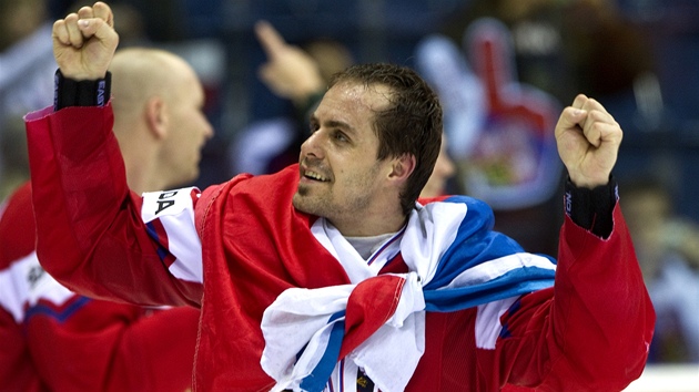 JO! Kapitn eskch hokejist Tom Rolinek s vlajkou kolem krku a bronzovou medail na nm.