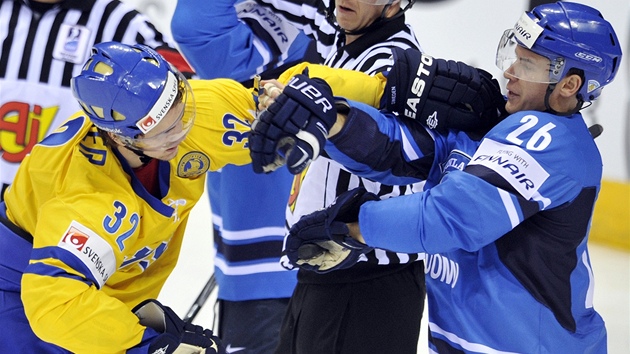 KONFLIKT. véd Marcus Krüger se postrkává s finským hokejistou  Jarkko Immonenem pi finále MS.