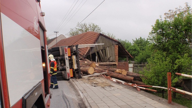 Nehoda v Osíku na Kromísku, pi které se v zatáce pevrátilo nákladní auto naloené kládami na bok. Z korby se pak kmeny uvolnily a mimo jiné zboily ást stodoly u silnice.