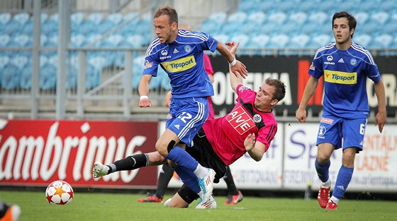 Rastislav Bakala (uprosted) z eských Budjovic odkopává mí ped olomouckým Jakubem Petrem.