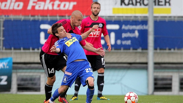 NEPUSTÍM T. Budjovický fotbalista Tomá Stráský se snaí zastavit olomouckého protivníka Jana Navrátila za kadou cenu.