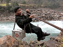Léka zavený na ocelovém lan rukuje pes eku Nu v provincii Junnan na jihozápad íny