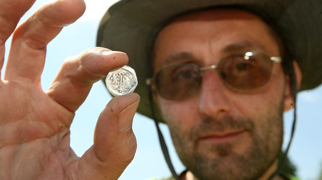 Archeologové zkoumají dno Staromstského rybníka v Teli (archeolog David Zimola ukazuje nález stedovké mince)