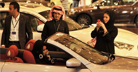 Saúdka fotí svou pítelkyni sedíci v kabrioletu na výstav automobil v Didd. eny v Saúdské Arábii nemohou získat idiský prkaz a tudí ídit (12. prosince 2010)