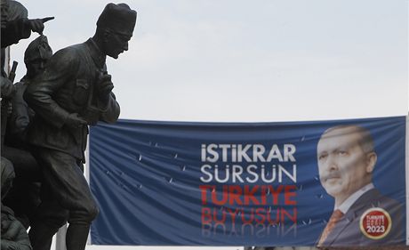 Socha zakladatele Turecké republiky Mustafa Kemala Atatürka bdí nad volebním plakátem Erdogana