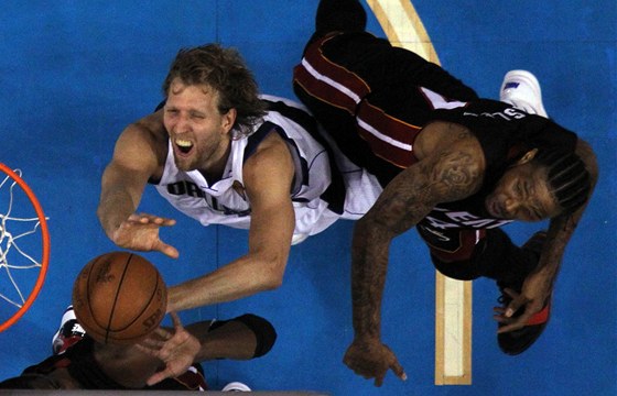 Dirk Nowitzki z Dallasu Mavericks zakonuje pes obranu Udonise Haslema (vpravo) z Miami Heat bhem pátého finále NBA.