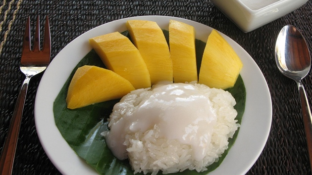 Jeden z oblíbených thajských dezert  lepkavá rýe se zálivkou z kokosové smetany, podávaná s mangem