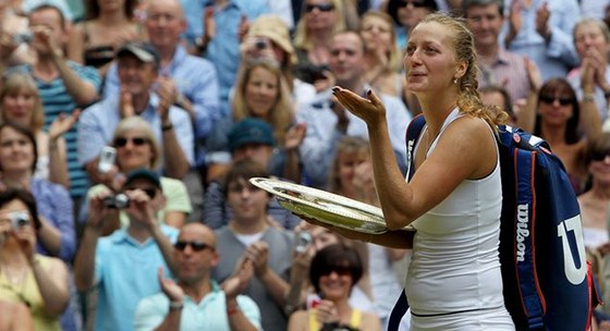 Petra Kvitová odchází z centrálního dvorce. S wimbledonskou trofejí posílá