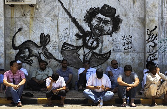Libyjci odpoívají pod graffiti v Benghází. (8. ervence 2011)