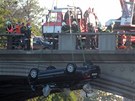 Auto, které po nehod na Hlávkov most prorazilo zábradlí a sjelo do Vltavy.