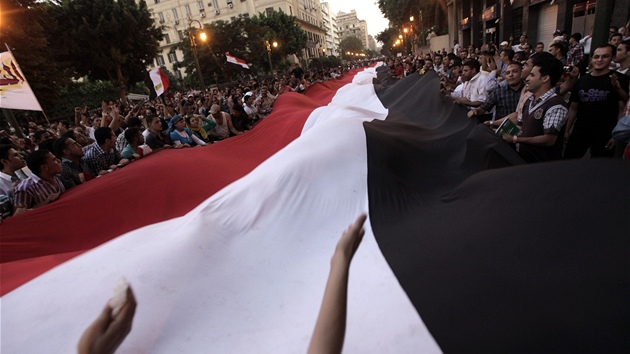 Demonstranti kráí s obí egyptskou vlajkou centrem Káhiry (12. ervence 2011)