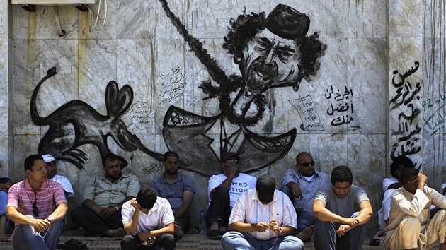 Libyjci odpoívají pod graffiti v Benghází. (8. ervence 2011)