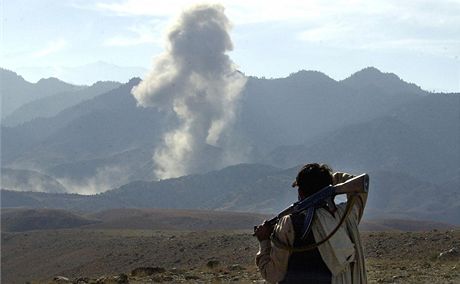 Afghánský bojovník sleduje ostelování skalního komplexu Tora Bora na hranicích