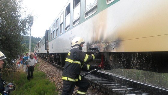 Hasii likvidují poár vagonu rychlíkové soupravy u Hrdjovic na