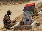 Libyjsk rebel sed u hrobu svho spolubojovnka v Benghz (21. ervence
