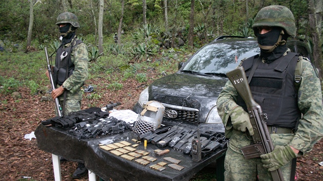 Mexit vojci stoj u munice a vyslaek, kter po pestelce objevili ve vcvikovm tboe drogovho kartelu Templ v lese nedaleko mexickho msta Santa Gertrudis. (14. ervence 2011)