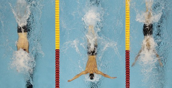 KLASICKÝ OBRÁZEK. Michael Phelps (uprosted) v ele závodu na 100 m motýlek.