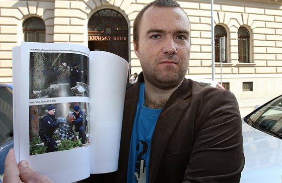 Aktivista Martin Marek ukazuje ped Krajský soudem v Plzni dokumenty a