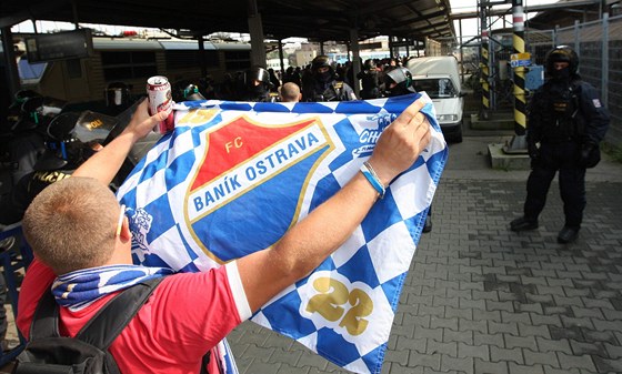 BANÍK! Fanouek ostravských fotbalist mává na olomouckém nádraí vlajkou svého