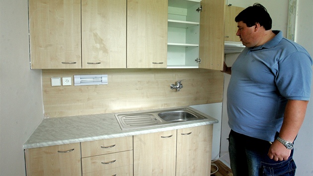 Mstostarosta Obrnic Stanislav Zaspal ukazuje novou kuchyskou linku v byt, kter radnice nabdla Ann H.