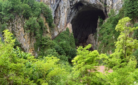 Vstup do jeskyn je skvle patrný z irokého okolí. Jen vegetace u jeho paty trochu sniuje velkolepý dojem.