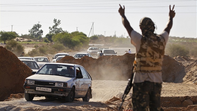 Libyjský rebel zdraví prchající obyvatele msta Závíja (14. srpna 2011)