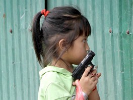 Malá holika s ostraitým pohledem kráí mezi plovoucími domy na ece Mekong
